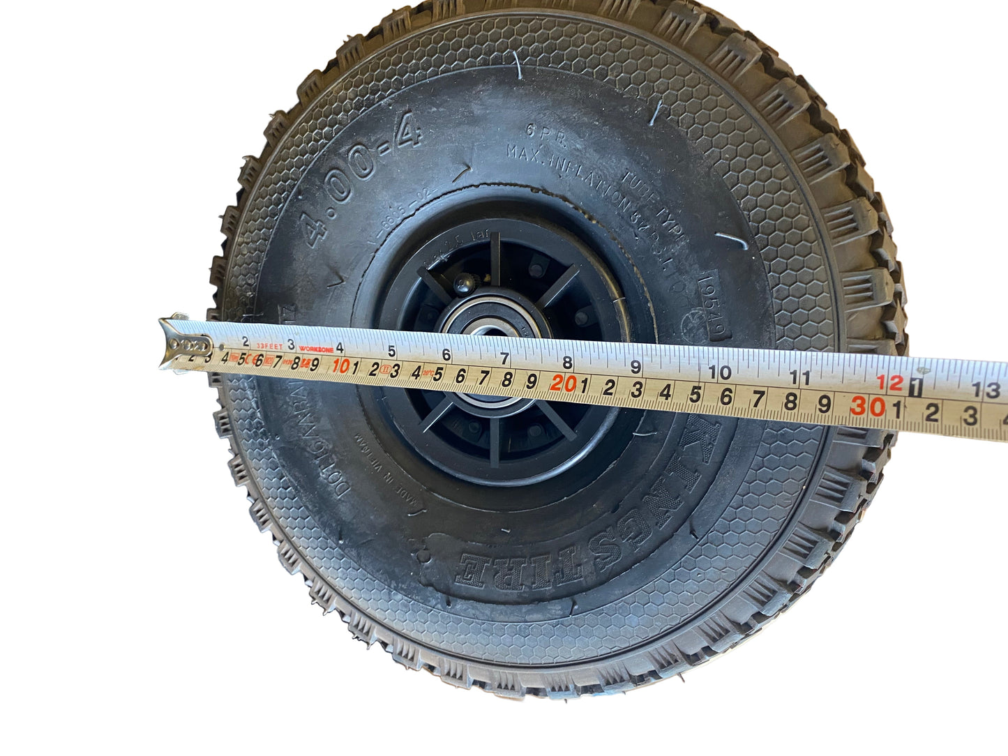 Tyre with a measuring tape showing its width.